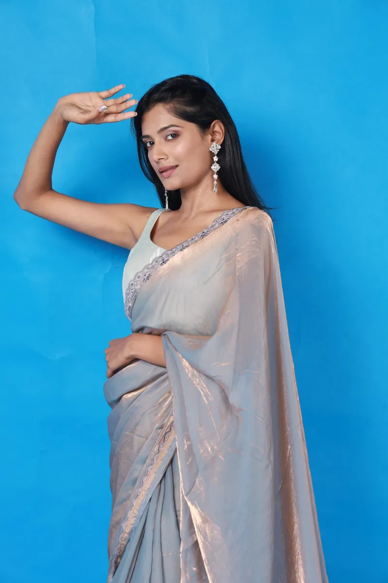 Snehal Patil in a grey saree against a blue backdrop